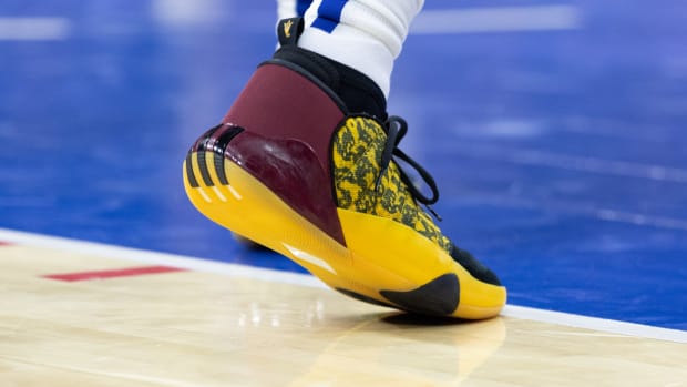 View of maroon and gold adidas Harden shoes.